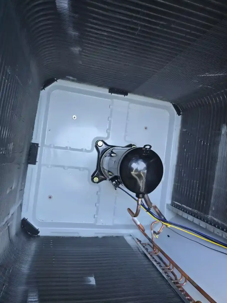 EMAX HVAC technician performing AC repair on outdoor condenser unit in San Antonio TX